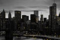 Yellow lights shiningÃÂ in black and white night time cityscape with the Brooklyn Bridge and buildings of Manhattan in New York